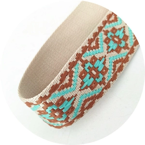 Detail view of ethnic geometric jacquard strap with brown and turquoise weaving patterns