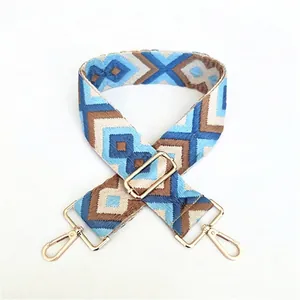 Detail of adjustable geometric woven strap with gold metal hooks and blue pattern
