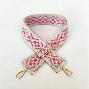 Detail of adjustable ethnic style woven strap with geometric patterns and gold metal hooks