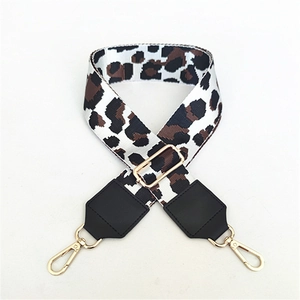 Detailed view of adjustable leopard print bag strap with golden metal swivel hooks