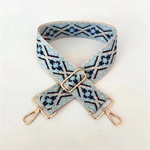 Close-up of ethnic geometric woven purse strap with golden metal swivel hooks and adjuster