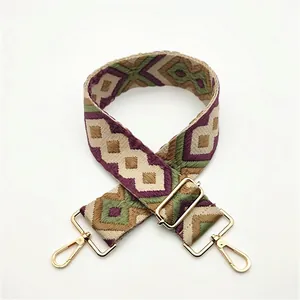 Detail of bohemian woven purse strap with purple geometric patterns and gold metal clasps