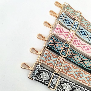 Detail view of ethnic woven shoulder straps with geometric patterns and golden metal hooks