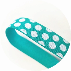 Macro view of adjustable polka dot bag strap in tiffany blue with elastic texture
