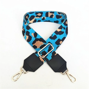 Close-up of leopard print woven bag strap with adjustable gold buckle and swivel hooks