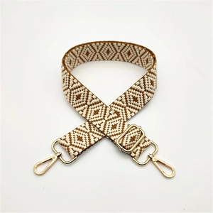 Detail of adjustable geometric ethnic style woven strap with golden swivel hook hardware