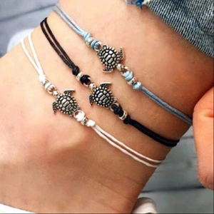 Three-piece ocean style woven turtle anklets in light blue, black and white wax ropes