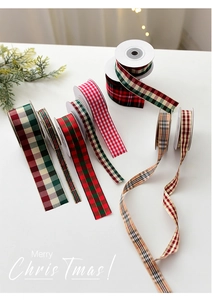 Close-up of festive plaid Christmas ribbons with gold trim for gift wrapping decor