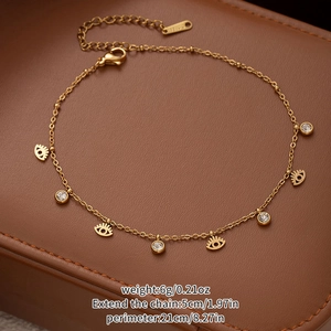 Detailed macro view of gold titanium steel anklet with evil eye charms and zircons