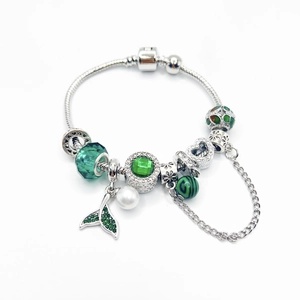 Silver snake chain bracelet with green glass beads, pearl, and sea fish tail pendant