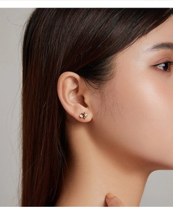 Detailed close-up of S925 silver bee stud earring with gold plating on a model ear