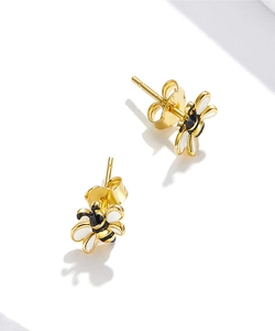 Detailed macro of gold-plated S925 silver bee studs with black and white enamel wings