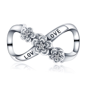 Macro shot of silver infinity charm with zircon flowers and LOVE engraving for bracelet