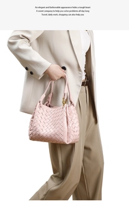 Close-up of pink woven leather tote bag with metal buckles and intricate cross-weave texture