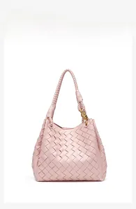 Detail of pink hand-woven shoulder bag featuring a luxury gold knot metal buckle accent