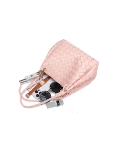 Pink hand-woven leather bucket bag showing interior space with daily essentials