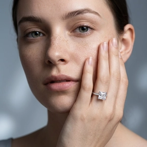 Classic princess cut solitaire ring in silver finish worn by a model on a blue background