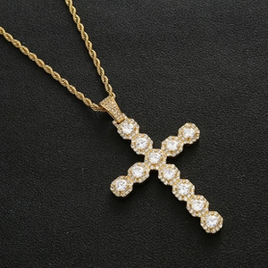 Detailed macro view of a gold-plated cross pendant with white zircon stones on rope chain