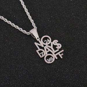 Macro shot of silver hip hop pendant with No Days Off text and inlaid zircon stones