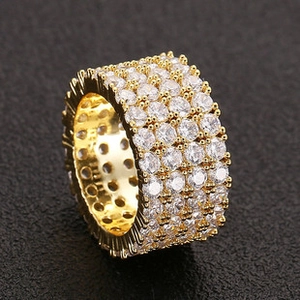 Macro shot of gold-plated iced out ring with four rows of prong-set cubic zirconia stones