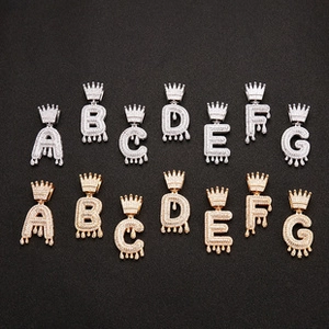 Close-up of hip-hop drip crown alphabet pendants with gold and silver iced out stones