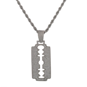 Macro detail of iced out silver razor blade pendant with micro-pave cubic zirconia