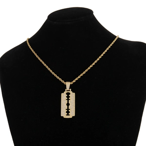 Detailed close-up of gold hip-hop razor pendant with pavé cubic zirconia on twisted rope chain