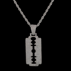 Macro view of hip hop razor blade pendant with pavé cubic zirconia on rope chain
