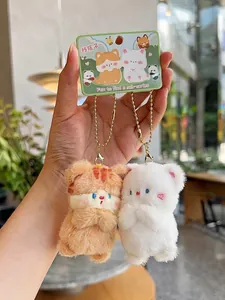 Detail of plush cat couple charms with orange stripes and white fur on a green card