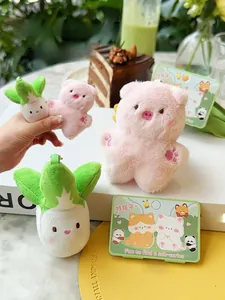 Detailed view of pink pig and green cabbage magnetic plush keychains on display card