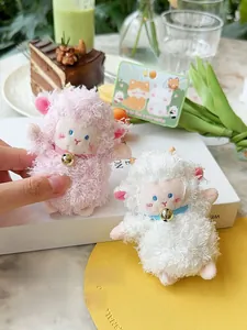 Close-up of magnetic plush lamb keychains in pink and white with golden bells