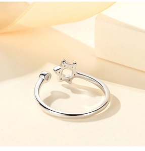 Detail view of S925 sterling silver hexagram ring with bead on warm gift backdrop