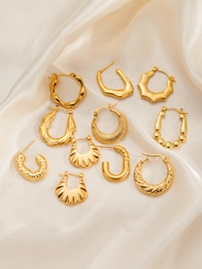 Collection of textured gold-plated titanium steel hoop earrings on silk fabric