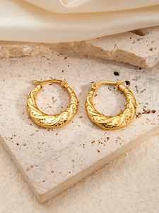 Detail view of gold-plated stainless steel earrings with vintage embossed textures on stone