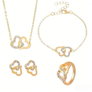 Parure de bijoux dorés avec doubles cœurs entrelacés et strass blancs sur fond blanc