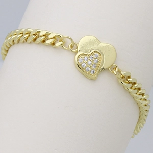 Close-up of golden Cuban chain bracelet with double heart charms and zircon stones