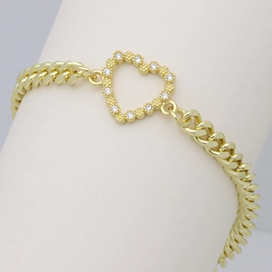 Detailed view of a gold Cuban chain bracelet featuring a zircon-studded heart pendant