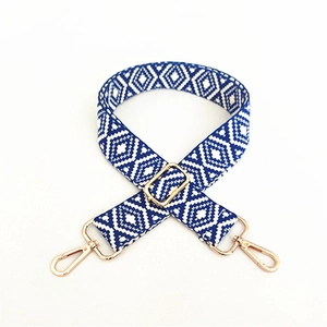 Détail de la bandoulière tissée géométrique bleu et blanc avec attaches en métal doré