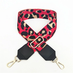 Detail of red leopard print adjustable PU leather strap with golden metal lobster clasps