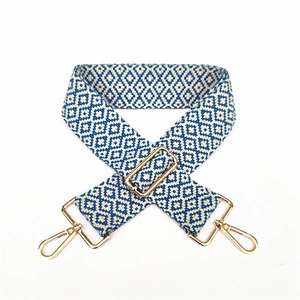 Macro view of blue and white geometric jacquard strap with gold-tone metal hardware