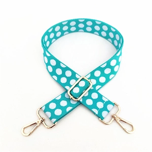 Close-up of adjustable polka dot bag strap in teal green with gold metal swivel snap hooks