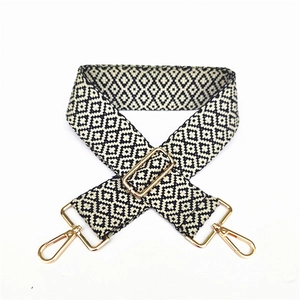 Detail of bohemian geometric pattern woven bag strap with golden metal swivel hooks