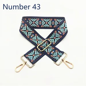 Ethnic geometric pattern wide adjustable bag strap with gold metal hooks on white background