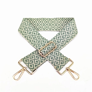 Detail view of woven geometric diamond purse strap with polished gold swivel hooks