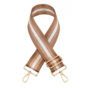 Close-up of brown and white wide shoulder strap with gold metallic thread and hardware
