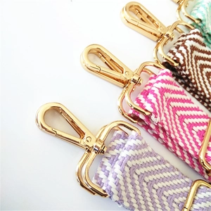 Close-up of woven chevron bag straps with premium gold lobster clasps and vibrant textures