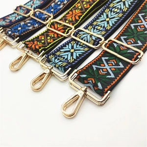 Detailed weave of geometric ethnic guitar style straps with golden metal hooks