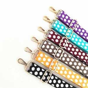Close-up of adjustable polka dot shoulder straps with gold metal hooks in multiple colors