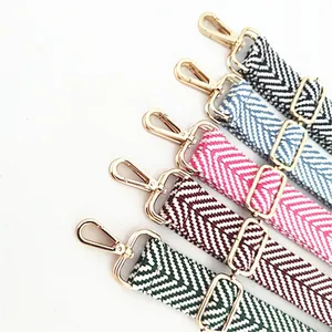 Detail showing five thick woven adjustable bag straps with golden lobster clasps