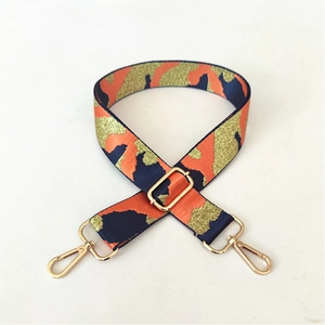 Close-up of wide camo bag strap with orange and blue metallic thread and gold lobster clasps